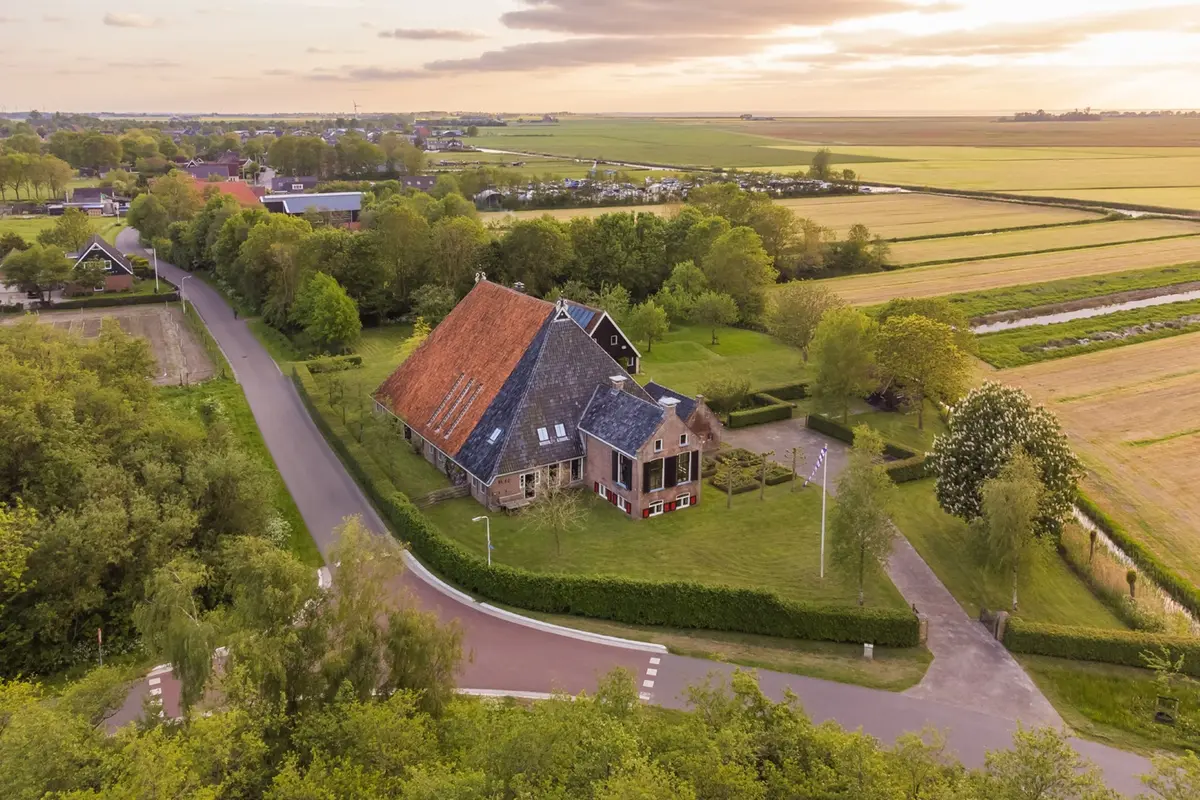 Woning bij schemer met verlicht interieur en een vuurkorf
